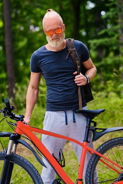 Старый велосипедист катается на велосипеде в природном парке на открытом воздухе — стоковое фото