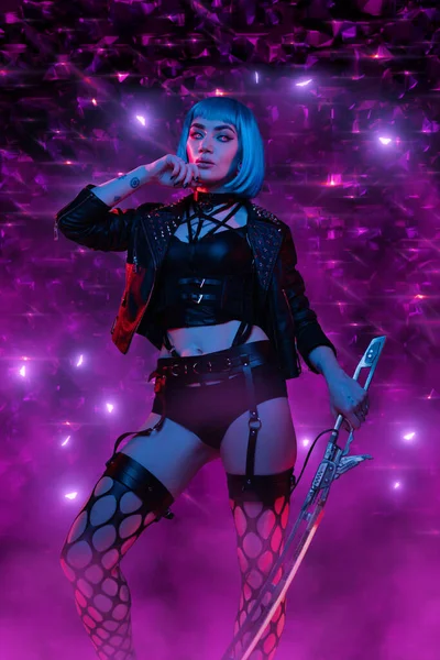 Cyberpunk vrouw met zwaard poseren tegen glanzende paarse achtergrond — Stockfoto