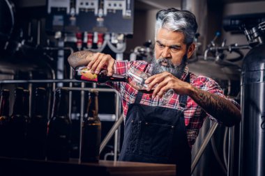 Neşeli bira üreticisi Şişeden cama bira dolduruyor