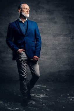 Koyu mavi ceketli, esmer, zarif yaşlı bir adam.