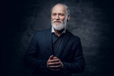 Koyu renk ceketli, esmer, neşeli yaşlı bir adam.