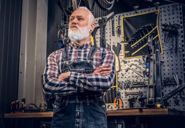 Kendine güveni tam yaşlı bir adam dükkandaki bankın etrafında takılıyor.