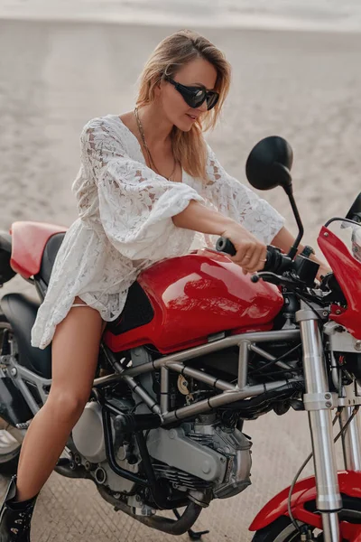Mulher relaxante na praia com sua moto personalizada — Fotografia de Stock