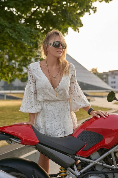 Stijlvolle vrouw biker met zonnebril en motorfiets buiten — Stockfoto