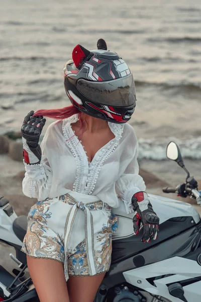 Mulher motociclista despreocupado posando com motocicleta contra a paisagem marinha — Fotografia de Stock