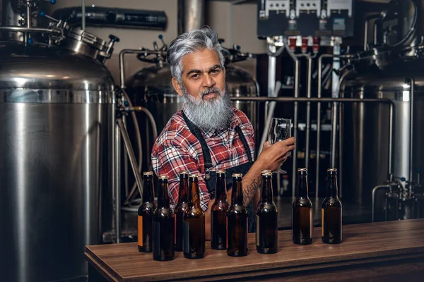 Homem idoso produzindo cerveja de qualidade na cervejaria moderna — Fotografia de Stock