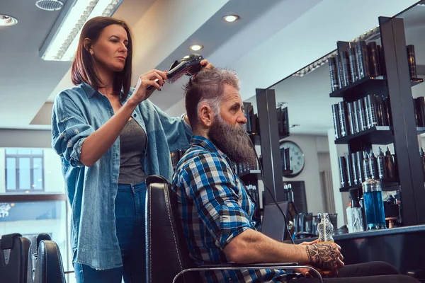 Cabeleireiro mulher cortando cabelos de homem velho hupster na barbearia — Fotografia de Stock