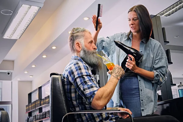 Cabelos de corte cabeleireiro mulher de hipster idoso com suco — Fotografia de Stock