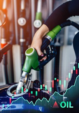 Benzin istasyonunda elinde tabanca olan bir kadının fotoğrafı.