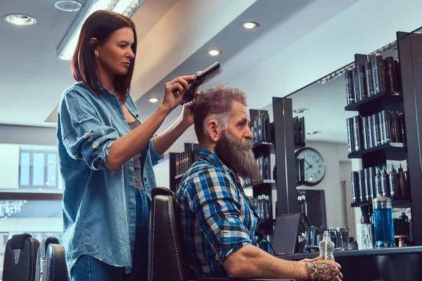 Cabeleireiro mulher cortando cabelos de homem velho hupster na barbearia — Fotografia de Stock