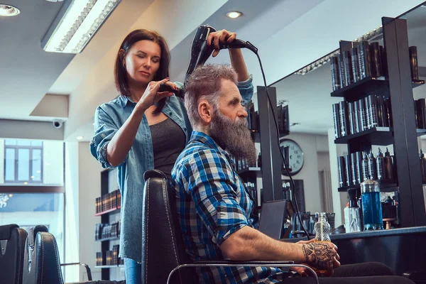 Barbearia moderna e mulher secando cabelos de homem velho — Fotografia de Stock