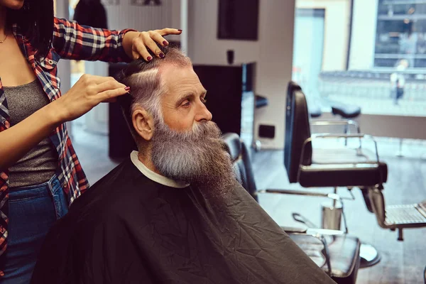 Mulher barbeiro corte hipster idosos com longa barba na barbearia — Fotografia de Stock