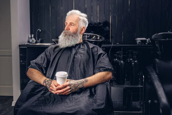 Tattooed elderly hipster with black peignoir and coffee — 스톡 사진
