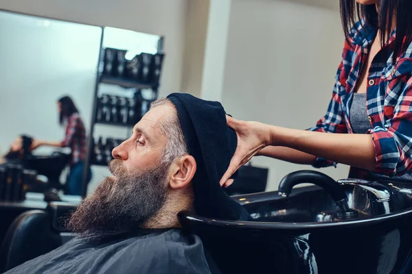 Mulher barbeiro lavar cabelos de barbudo hipster idosos — Fotografia de Stock