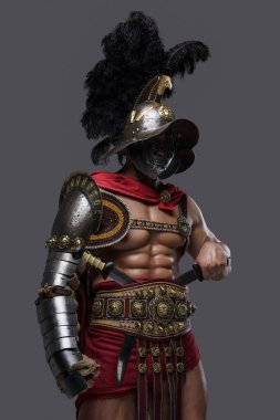 Gri arka plana karşı ikiz kılıçlı üstsüz kolezyum savaşçısı