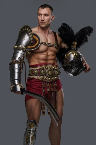 Muskulös grekisk gladiator med pluggad hjälm och kort svärd — Stockfoto