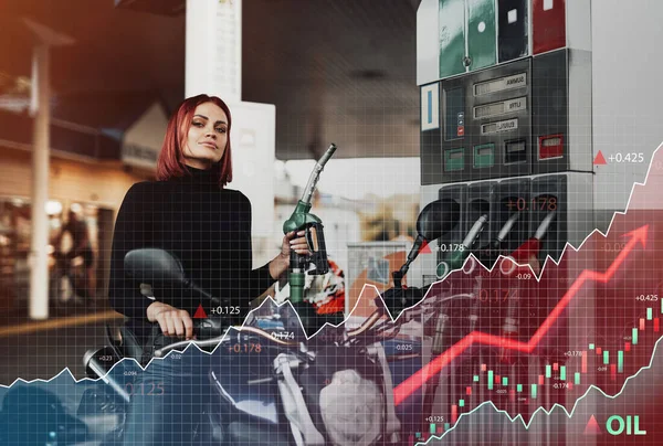 Motosikletli neşeli kadın benzin istasyonunda motorcusunu dolduruyor.