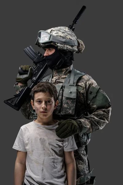 Shot of young kid and brave army man with rifle — Stockfoto
