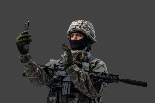 Soldado da Ucrânia com celular contra fundo cinza — Fotografia de Stock
