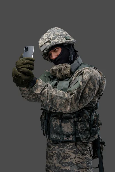 Soldat från ukrainska tar selfie mot grå bakgrund — Stockfoto