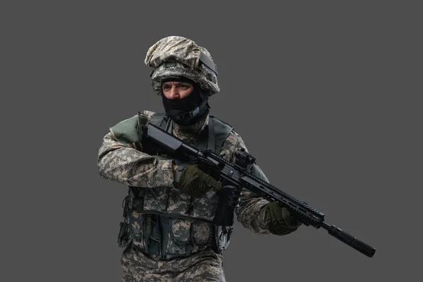 Militar homem com rifle vestido com uniforme de camuflagem e capacete — Fotografia de Stock
