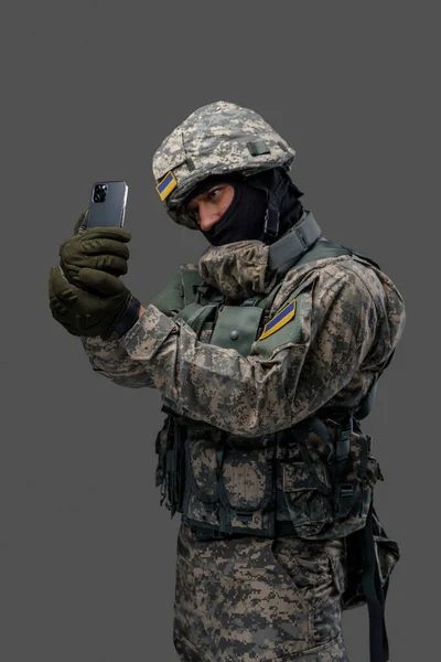 Soldier from ukraine taking selfie against gray background — Stockfoto