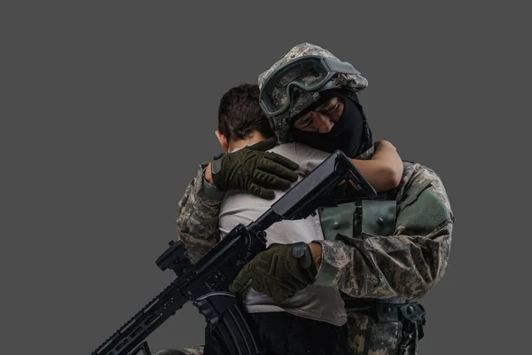 Army man embracing little kid isolated on gray background — Photo