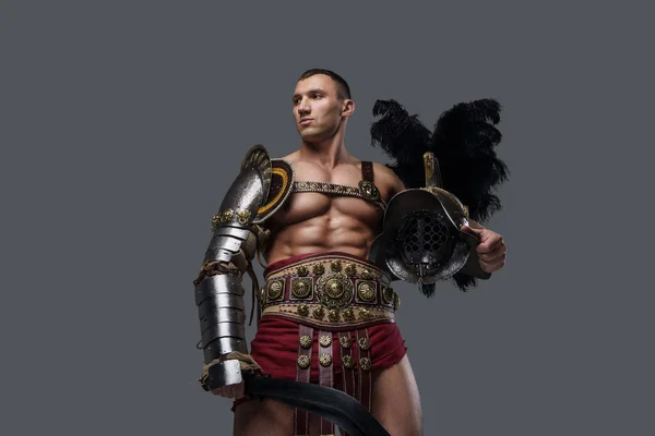 Handsome gladiator swordsman with helmet isolated on grey background — Stock Photo, Image