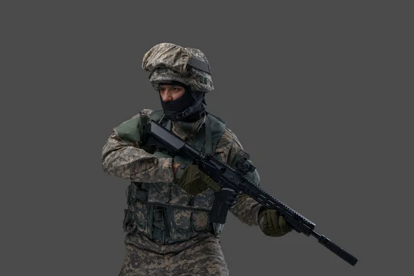 Military man with rifle dressed in camouflage uniform and helmet — Stok fotoğraf