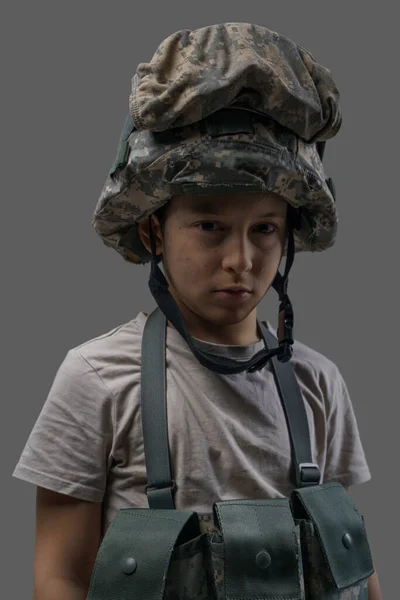 Criança militar pré-escolar com capacete de camoflagem e colete — Fotografia de Stock