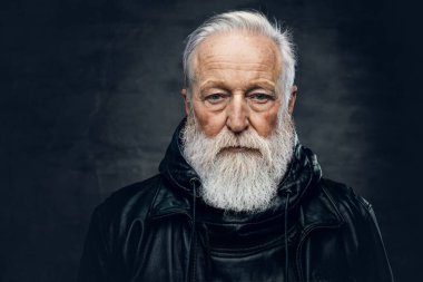 Deri ceketli, esmer, sakallı yaşlı bir adam.