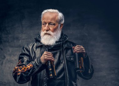 Siyah arka planda iki şişe tutan şık büyükbaba motorcusu.