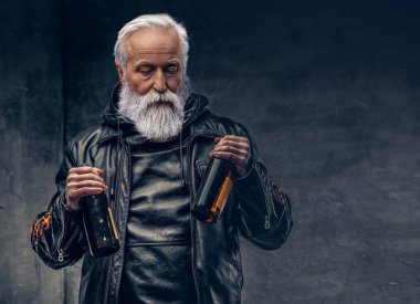 Siyah arka planda iki şişe tutan şık büyükbaba motorcusu.