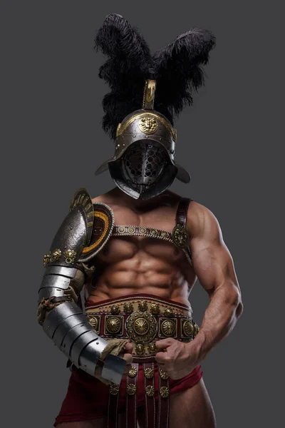 Sterke oude gladiator met gepruimde helm tegen grijze achtergrond — Stockfoto