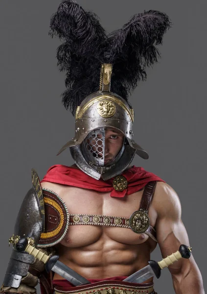 Muscular roman gladiator looking at camera against grey background — Stock Photo, Image