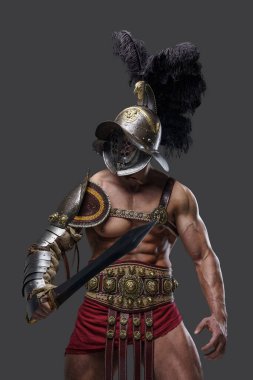Muscular arena warrior with gladius against grey background