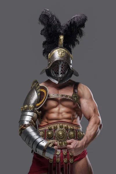 Strong ancient gladiator with plumed helmet against gray background — стоковое фото
