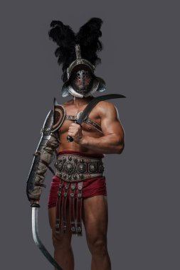 Elinde iki kılıç tutan tüylü miğferi olan Romalı gladyatör