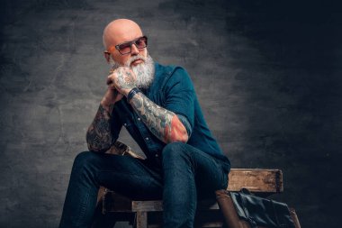 Tahtaya oturan dövmeli son sınıf öğrencisi.