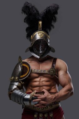Gri arka planda tüylü miğferi olan güçlü antik gladyatör