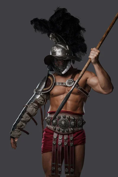 Gladiator spearman throwing spear against gray background — Fotografia de Stock