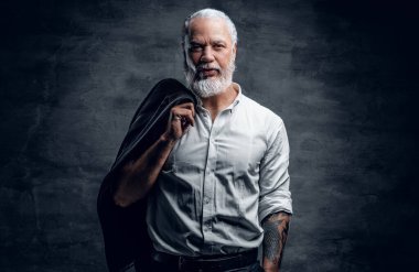 Omzunda bej ceketini tutan yaşlı bir adam.