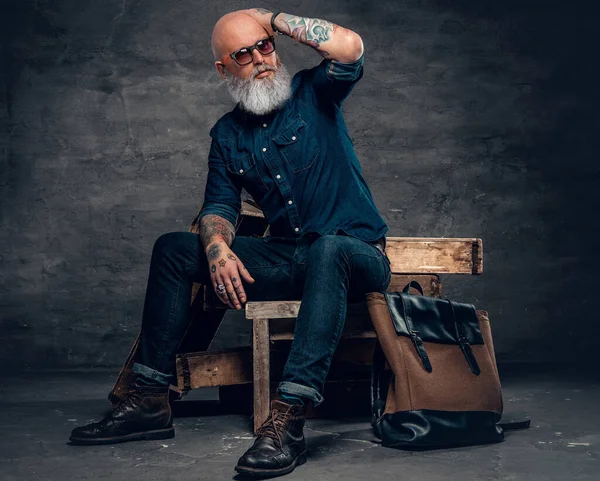 Tahtaya oturan dövmeli son sınıf öğrencisi.