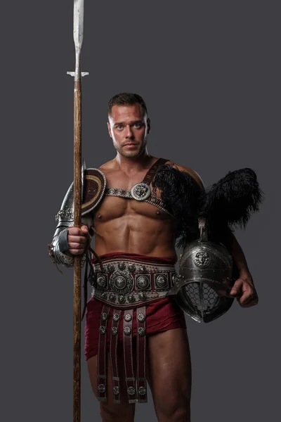 Gladiator spearman with muscular build against grey background — Stockfoto