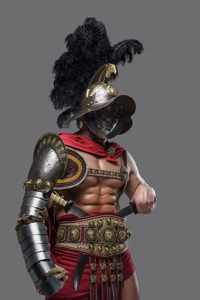 Coliseu guerreiro com capacete de plumed contra fundo cinza — Fotografia de Stock