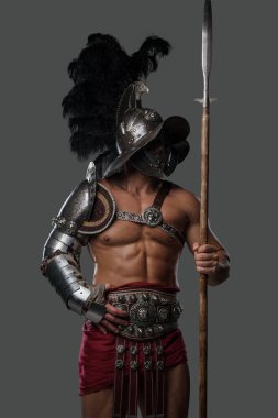 Gri arka planda miğferi olan görkemli gladyatör mızrakçısı