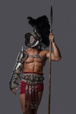 Gri arka planda miğferi olan görkemli gladyatör mızrakçısı