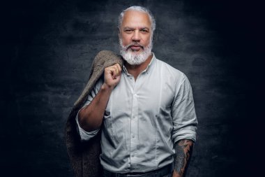 Omzunda bej ceketini tutan yaşlı bir adam.