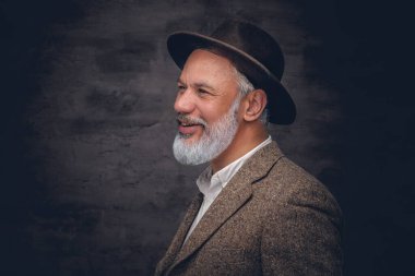 Siyah arka planda şapkası olan neşeli son sınıf öğrencisi.