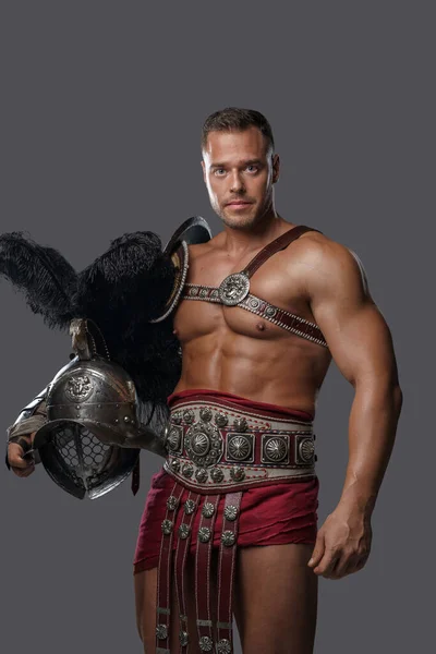 Muskulöser römischer Krieger mit Helm blickt in die Kamera — Stockfoto